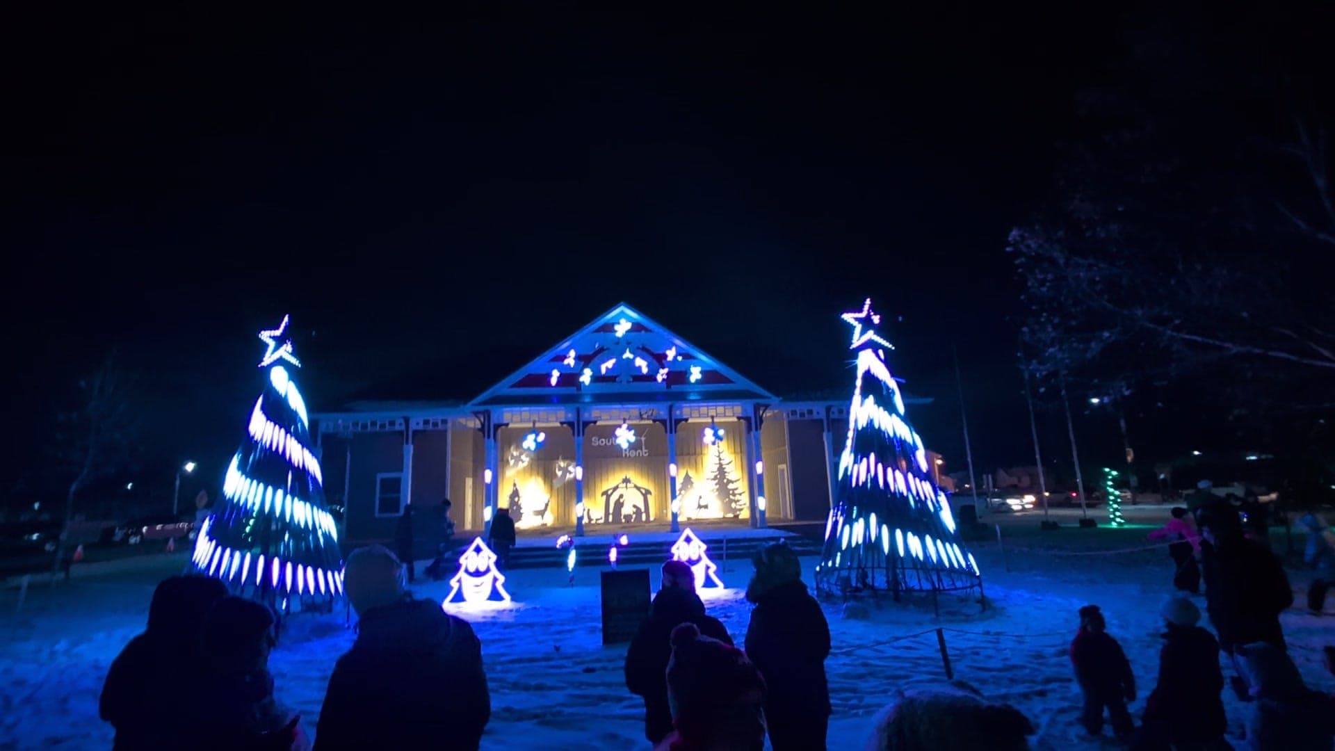 Candy-stripe mega trees and the crowd in front of the pavilion stage