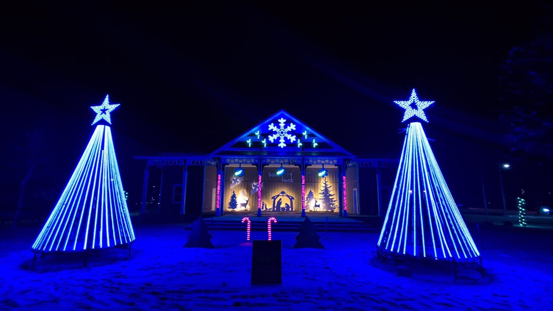 Pavilion stage with two blue pixel mega trees and star toppers at a Christmas light show in Chatham-Kent