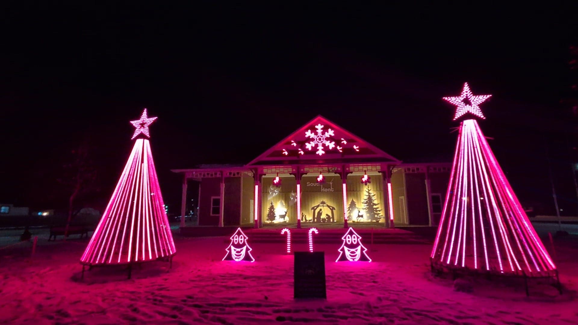 Stage show washed in magenta with snowflakes in the gable, Chatham-Kent park light show